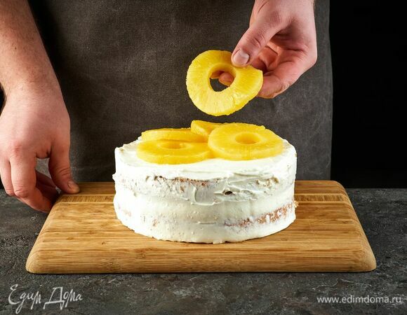 Соберите торт и сверху тоже смажьте кремом. Выложите кольца ананаса.