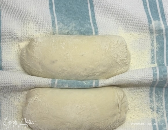 Включаем духовку и прогреваем до 220°C вместе с противнем. Аккуратно переносим чиабатту на противень с помощью доски. И сразу отправляем в духовку. Если у вас электрическая духовка, то плесните на дно немного воды для образования пара. Если газовая, то поставьте сковороду внизу, разогрейте и плесните воду в нее. Так появится хрустящая корочка.