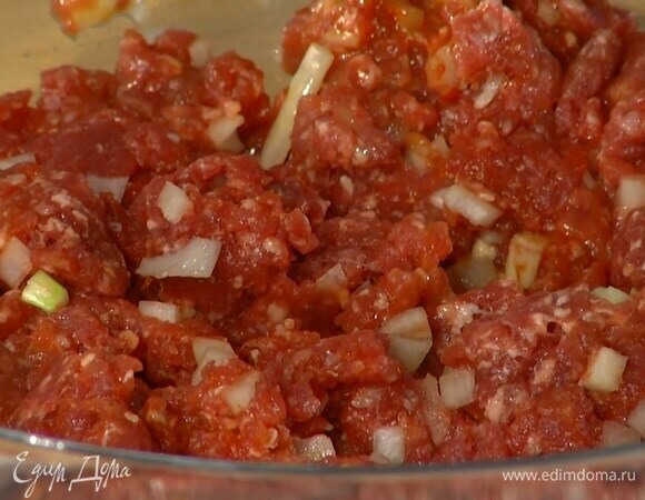 К говяжьему фаршу добавить оставшийся лук, чеснок, томатную пасту, острый соус и яйцо, все посолить, поперчить и перемешать.