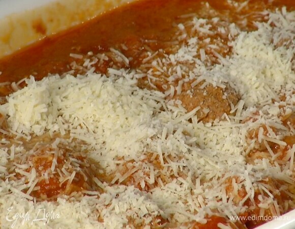 Переложить митболы в жаропрочную форму, посыпать натертым сыром и запекать в разогретой духовке 5 минут.