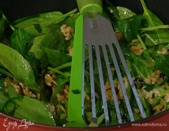 Выложить к овощам отваренный рис, все перемешать, добавить шпинат и дать ему немного привять, затем влить соевый соус и, помешивая, прогревать еще несколько минут.