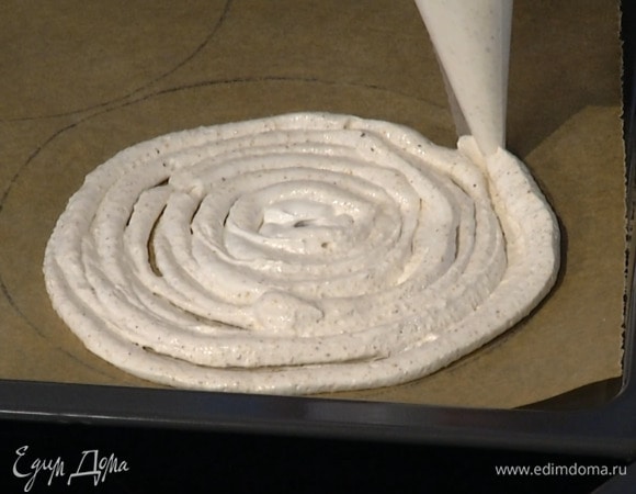 Противень выстелить бумагой для выпечки, начертить на ней 3 круга (можно обвести тарелку) и с помощью кондитерского мешка выложить в них взбитые белки.