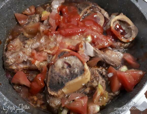 Добавьте нарезанный кубиками помидор, влейте вино и прогрейте пару минут на сильном огне.