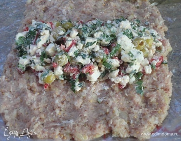 Фарш выложить на пищевую пленку прямоугольником, по центру разместить начинку. С помощью пленки завернуть края и сформовать рулет.