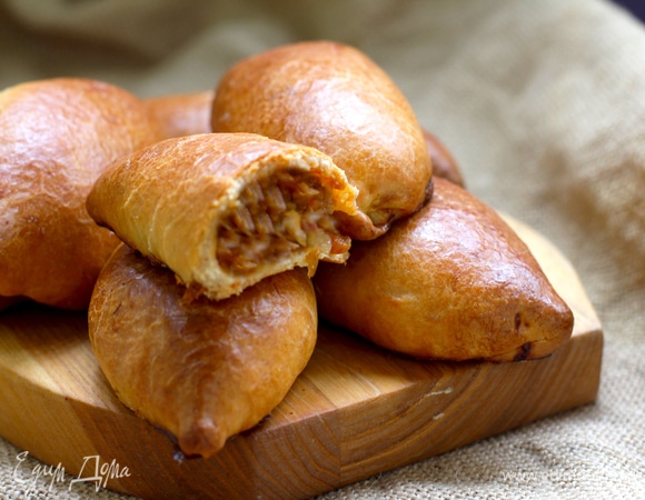 Достать пирожки и сразу смазать теплым молоком при помощи кисточки. Накрыть полотенцем минут на 10 для большей мягкости.