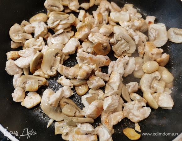 К курице добавить нарезанные шампиньоны и обжаривать еще 2–3 минуты.
