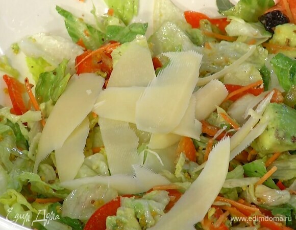 Твердый сыр нарезать тонкими хлопьями и выложить на салат.