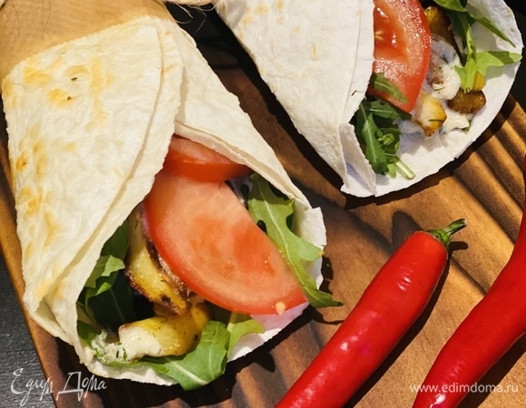 Далее раскрываем лепешку, выкладываем салатную смесь, курицу, соус, картошку, опять соус, несколько долек помидора и сворачиваем по краям.