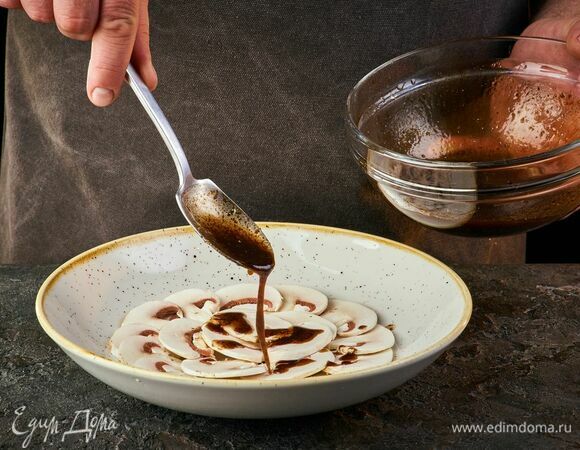 Выложите на тарелку нарезанные грибы и полейте заправкой. Сверху положите руколу, вяленые томаты, пармезан.