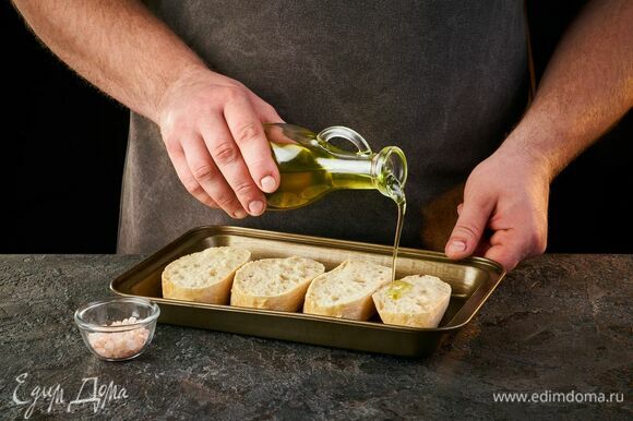 Хлеб полейте маслом и подсушите в духовке при 180°C до золотистого цвета.