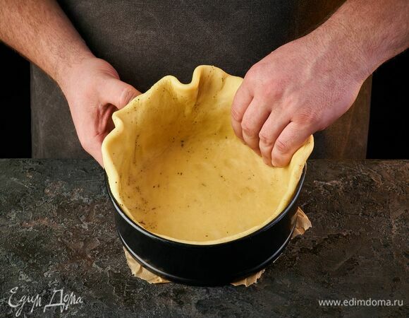 Достаньте тесто из холодильника и распределите его по форме, сформировав бортики. Проколите дно вилкой.