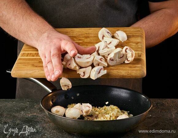 Добавьте крупно нарезанные грибы в сковороду и жарьте до тех пор, пока не выпарится лишняя жидкость.