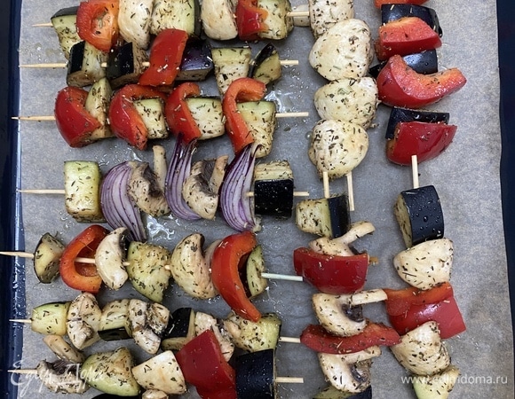 Нанизать овощи на шпажки, разложить на противень, застеленный пергаментом. Сбрызнуть оливковым маслом.