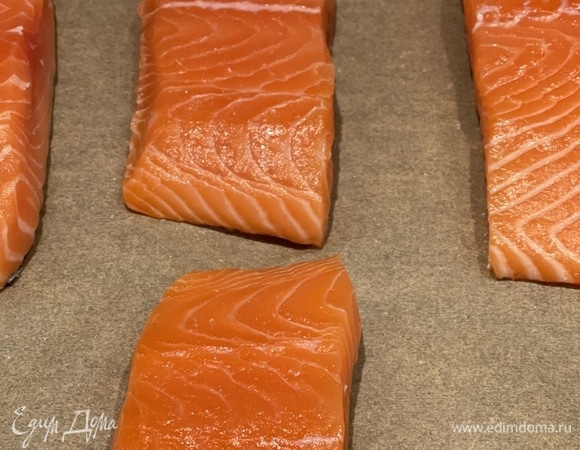 Рыбу нарезаем на порционные куски и вместе с кожей выкладываем на пергамент. После запекания кожа останется на бумаге. Солим по вкусу и отправляем в духовку, разогретую до 180°C, на 20 минут под гриль.