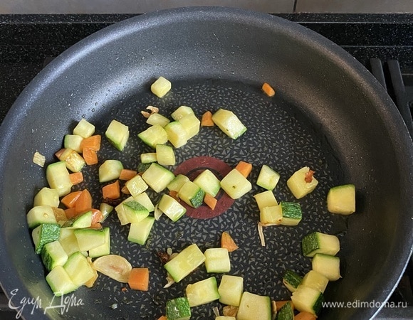 Цукини и морковь нарезаем кубиком, чеснок — кружочками, слегка обжариваем на оливковом масле.