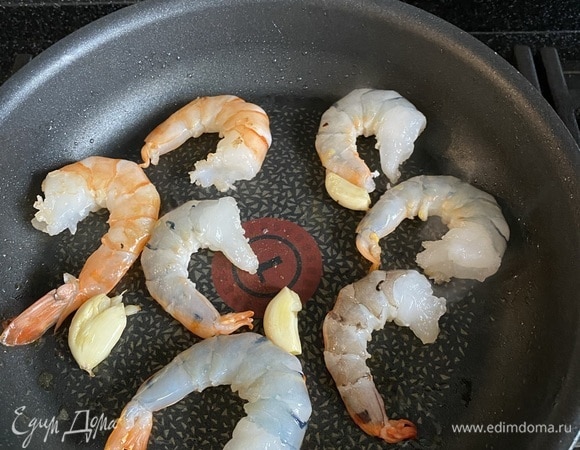 Два зубчика чеснока раздавливаем ножом, обжариваем их на оливковом масле, далее добавляем свежие королевские креветки и слегка обжариваем.