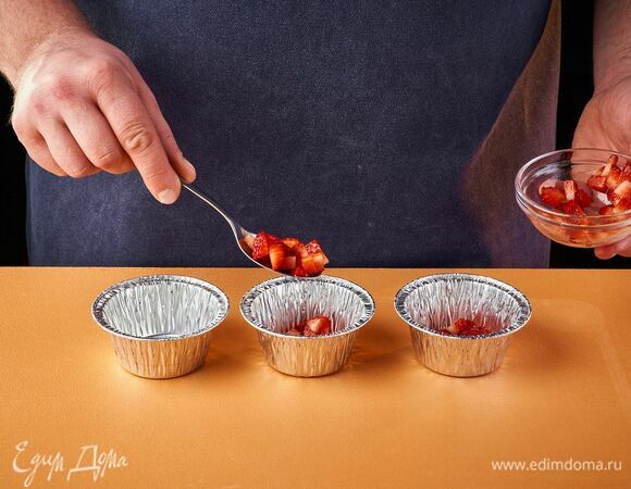 На дно каждой формочки выложите кусочки клубники.