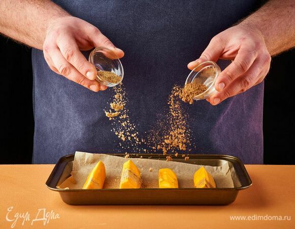 Тыкву почистите и нарежьте средними кусочками. Выложите дольки на противень, застеленный пергаментной бумагой, посыпьте корицей и кардамоном по вкусу. Запекайте тыкву в духовке при 180°C около 20 минут.