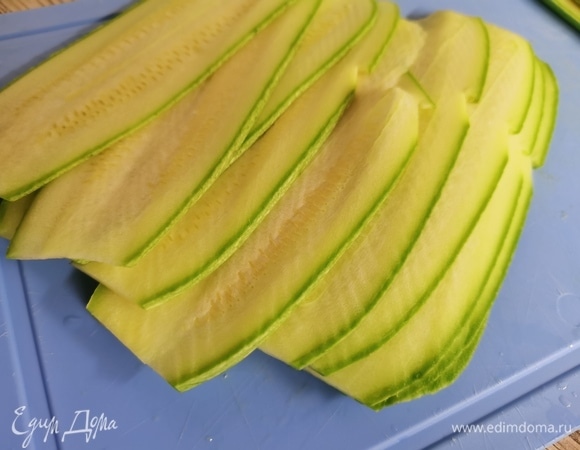 Кабачки нарезать на тонкие слайсы, чтобы мы легко смогли их свернуть. Удобно это делать широким ножом. Также отлично подойдет овощерезка или нож для чистки овощей.