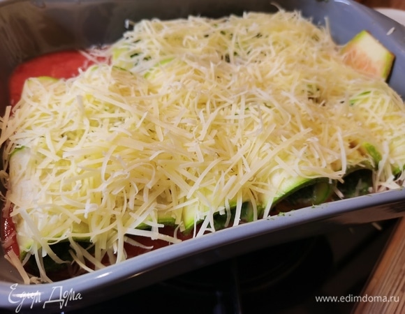 Сыр потереть на мелкой терке и посыпать им кабачки. Запекать 20 минут при 200°C.