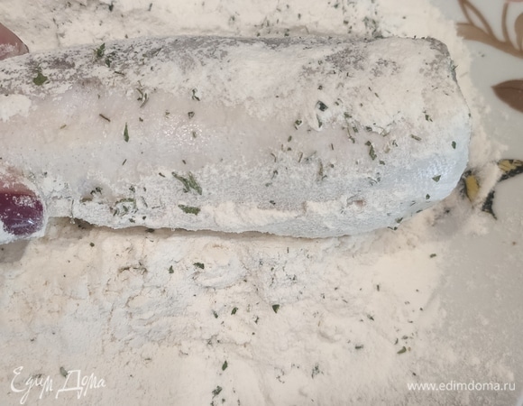 В муку добавить соль, перец, зелень и обвалять в ней рыбу.