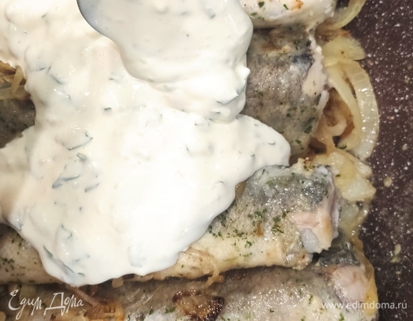 Рыбу выложить на лук, сверху — сметану, чеснок рубленый, добавить немного воды и тушить минут 25–30.