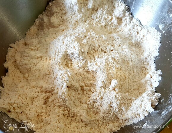 В муку добавить соль и холодное масло, нарезанное кусочками. Все перетереть в жирную крошку.