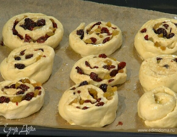 Свернуть тесто в рулет и нарезать его поперек, затем уложить получившиеся кружки на выстеленный бумагой для выпечки противень, смазать оставшимся растопленным маслом и посыпать сахаром.