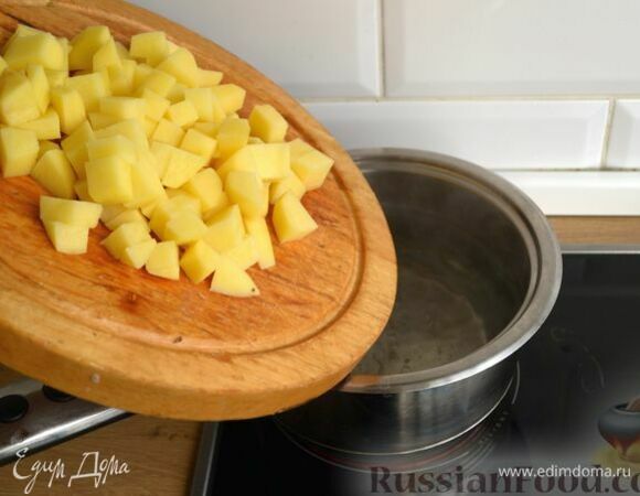 В кастрюлю налейте 1,5 л воды и на большом огне доведите до кипения. Картофель очистите, нарежьте крупными кубиками и отправьте в кипящую воду. Варите картофель до готовности (примерно 12–15 минут).