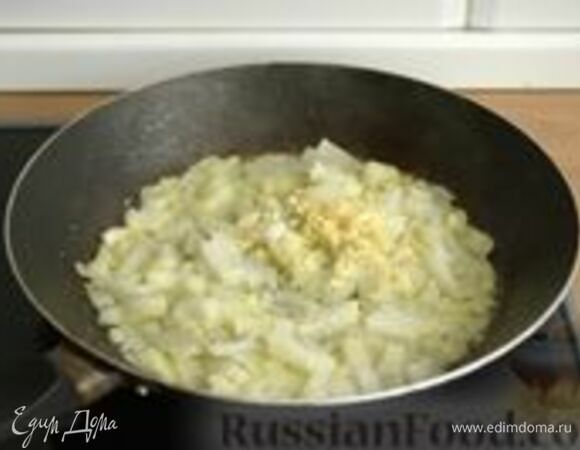 Очищенный лук нарежьте мелкими кубиками. Оставшийся очищенный зубчик чеснока мелко нарежьте. В другой сковороде растопите оставшееся сливочное масло и обжарьте лук и чеснок до золотистости.