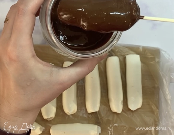 Холодные творожные сырки насаживаем на деревянные шпажки и окунаем в шоколадную глазурь. Даем глазури немного стечь и перекладываем изделия на тарелку или доску. Убираем в морозилку еще на 30 минут. Храним в холодильнике.