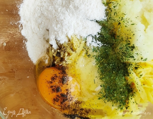 Делаем драники. Берем картофель (6 шт.) и натираем на крупной терке. Отжимаем его хорошенько и сливаем лишнюю жидкость. К картофелю натираем среднюю луковицу на мелкой терке, добавляем яйцо, 2 ст. ложки муки, соль, перец, сухую петрушку.