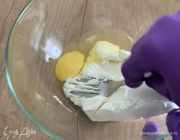 В миску выложите творог, разбейте яйцо и хорошо перемешайте.