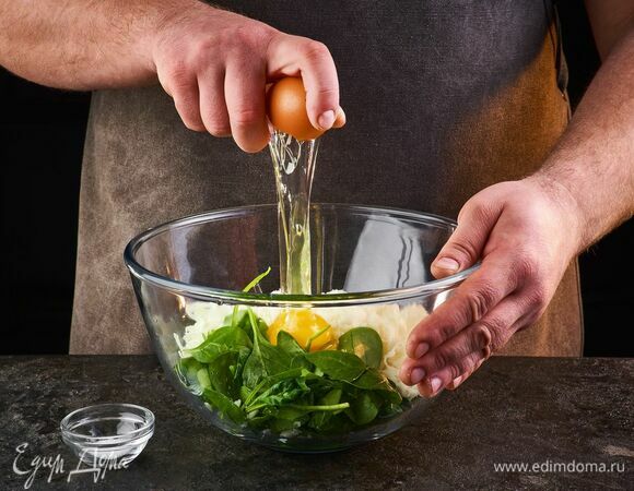 Шпинат промойте и мелко порубите. Выложите все в миску, добавьте яйцо, соль по вкусу, перемешайте.