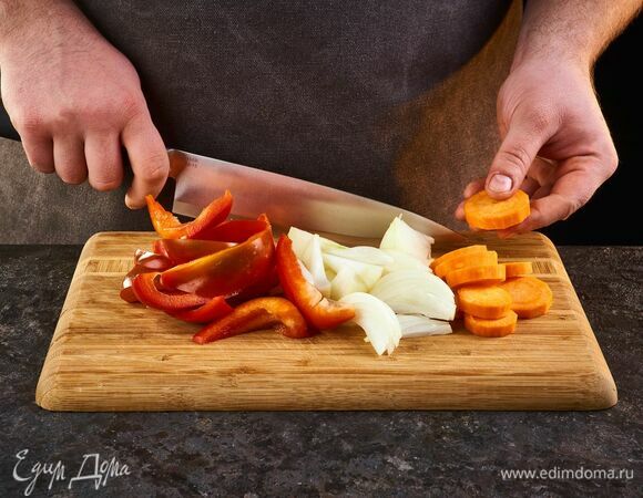 Лук нарежьте полукольцами, болгарский перец — брусочками, морковь — кружками.