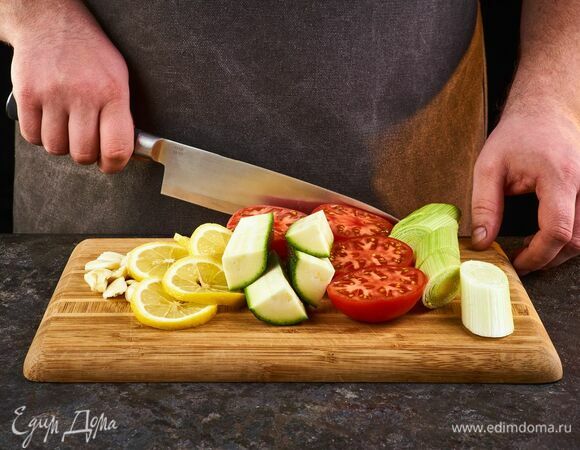 Цукини, помидоры, лук-порей крупно нарежьте. Чеснок мелко порубите, лимон нарежьте кольцами.