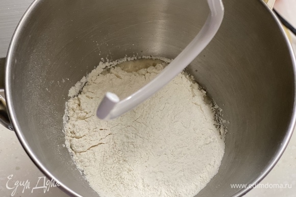 Добавить муку, соль и оставшийся сахар. Вымешивать тесто в течение 2–3 минут.