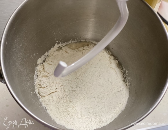 Добавить муку, соль и оставшийся сахар. Вымешивать тесто в течение 2–3 минут.
