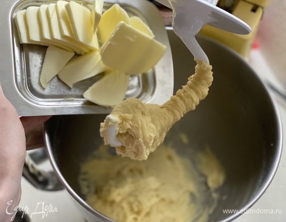 Добавить сливочное масло и вымешивать еще 3 минуты, до получения однородного теста.