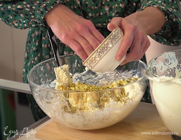 Половину взбитых сливок вмешать лопаткой в творожно-сливочную массу, добавить цукаты, фисташки, все перемешать, затем ввести оставшиеся сливки.