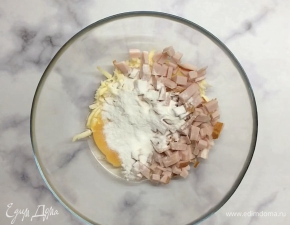 Сыр натираем на крупной терке, колбасу (ветчину или карбонад) мелко нарезаем и перекладываем в миску. Добавляем яйцо, муку и перемешиваем.