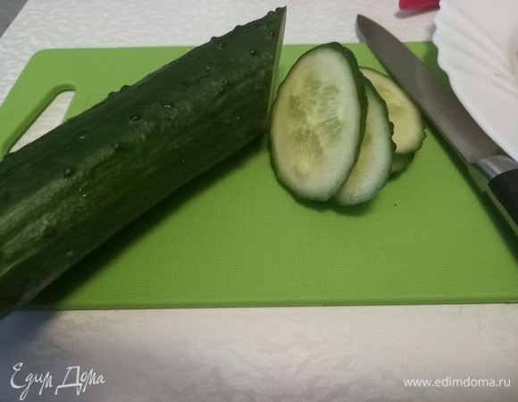 Огурец крупный, достаточно будет и половины. Нарезать слайсами наискосок.
