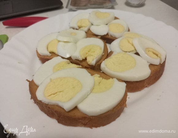 Выкладываем слайсы отварного яйца на хлеб поверх горчицы.