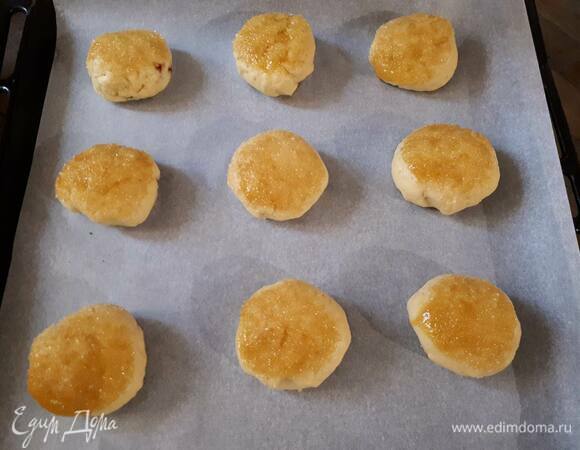 Сформируйте шарики из теста, затем расплющите каждый шарик. Положите 1ч. л. варенья (варенье не должно быть слишком жидким) и сформируйте пирожок. Обмакните его в яйцо, а затем — в сахар.