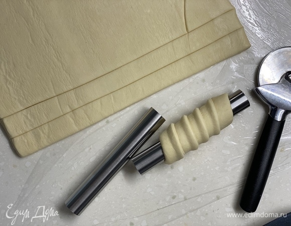 Тесто разрезать на одинаковые полоски диаметром 2 см. Аккуратно накрутить на трубочки.