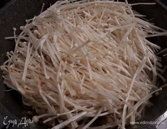 Добавьте эноки и обжарьте 3–4 минуты. Они станут мягкими и с виду похожими на лапшу.