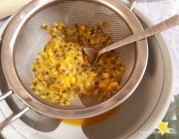 Выложите мякоть маракуйи (4 шт.) в сито и выдавите ложкой сок.