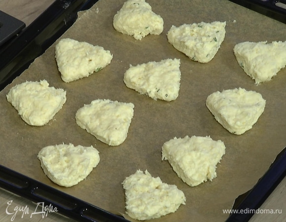 Рабочую поверхность присыпать оставшейся мукой, выложить тесто и сформировать из него пласт толщиной в сантиметр-полтора, затем кондитерским кольцом вырезать булочки и выложить на выстеленный бумагой для выпечки противень.