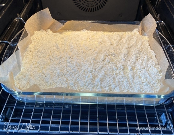 Для начинки смешать все ингредиенты венчиком до однородности. Консистенция получается жидкая, так и должно быть. Духовку разогреть до 190°C. Форму для запекания я застилаю пергаментом. В форму выложить 2/3 основы, вылить сверху всю начинку и сверху засыпать оставшуюся крошку.