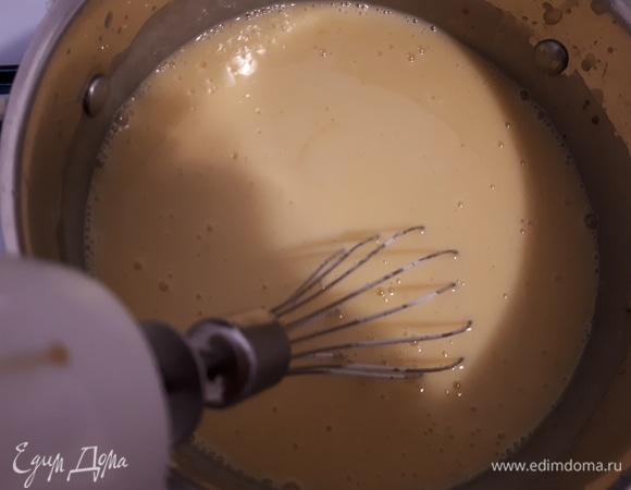 Когда молоко прогреется, удалите специи, всыпьте муку с сахаром и хорошо перемешайте миксером. Дайте остыть 10 минут. Затем добавьте желтки и яйца и взбейте.